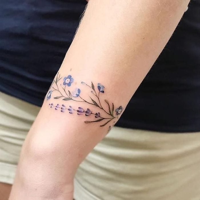 Tatuaje de flores y ramas en la muñeca
