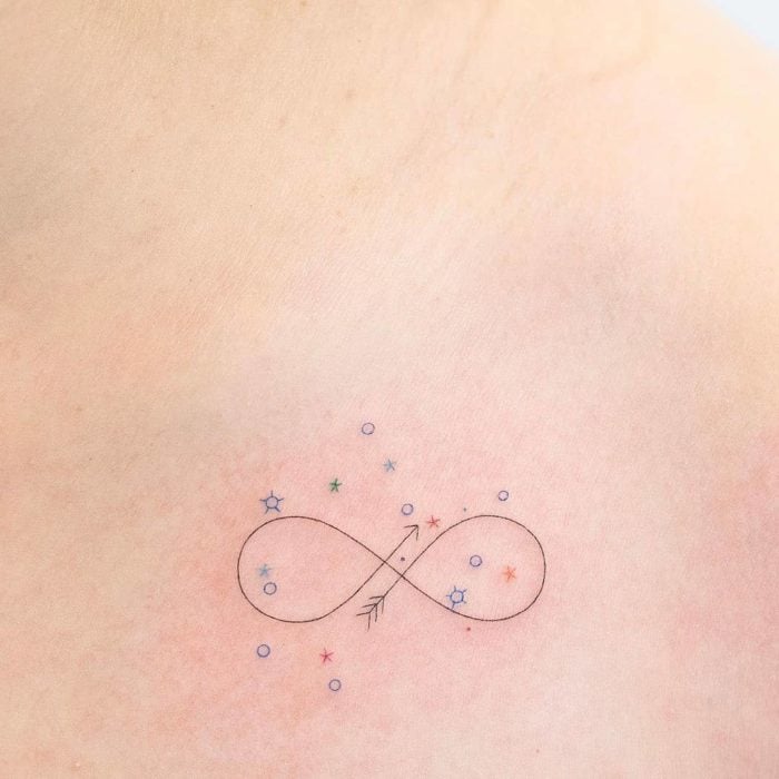 Tatuaje pequeño símbolo infinito y estrellas de colores