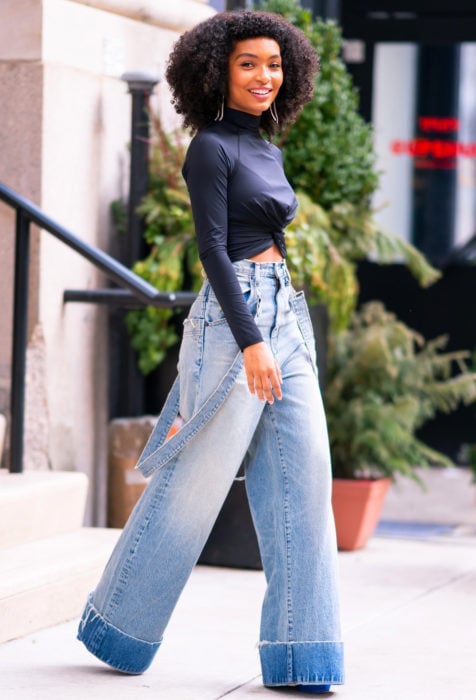 Looks con baggy jeans; mujer afroamericana con cabello chico y pantalones holgados