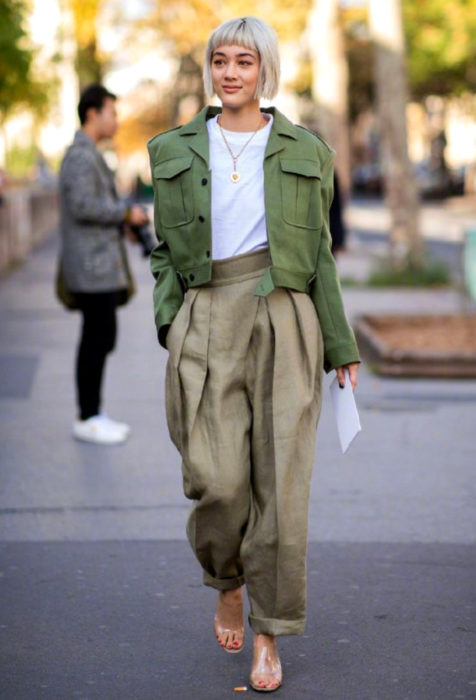 Looks con baggy jeans; mujer con corte de honguito, cabello rubio y fleco, con pantalón y saco oversized 