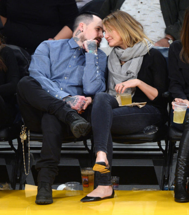 Cameron Diaz e Benji Madden seduti fissi a vicenda durante una partita di basket 