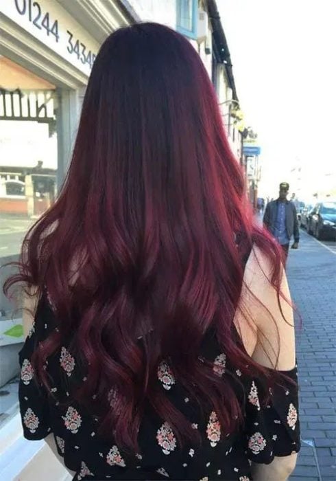 Chica de espaldas mostrando su cabellera larga en tono cherry wine