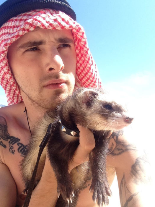 Chico posando junto su hurón en una foto 