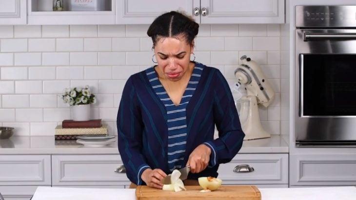 Chica llorando por cortar cebolla