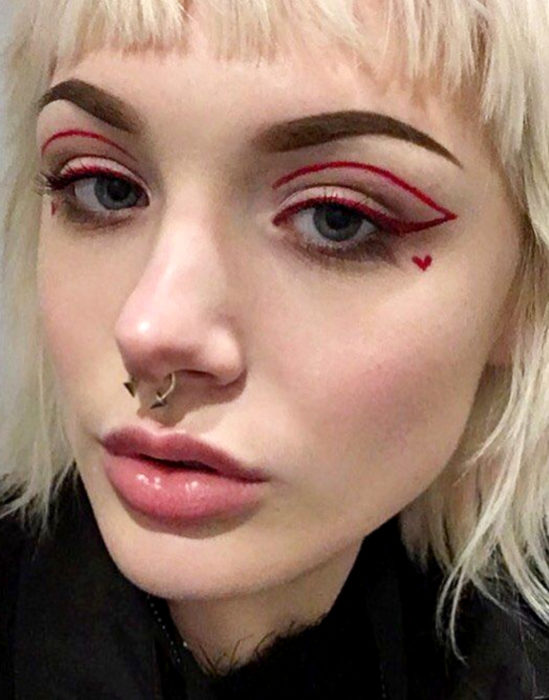 Maquillaje tendencia para el 2020;; delineado gráfico o flotante color rojo con un corazón en la mejilla