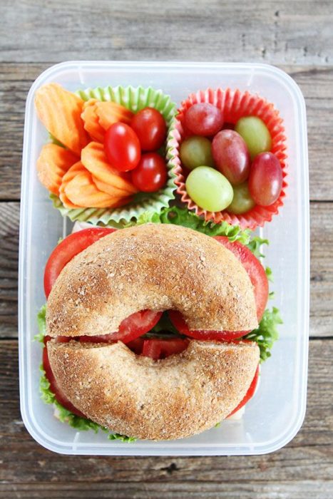 Bagle con tomate, lechuga, uvas rojas y verdes, tomate cherry y papas fritas