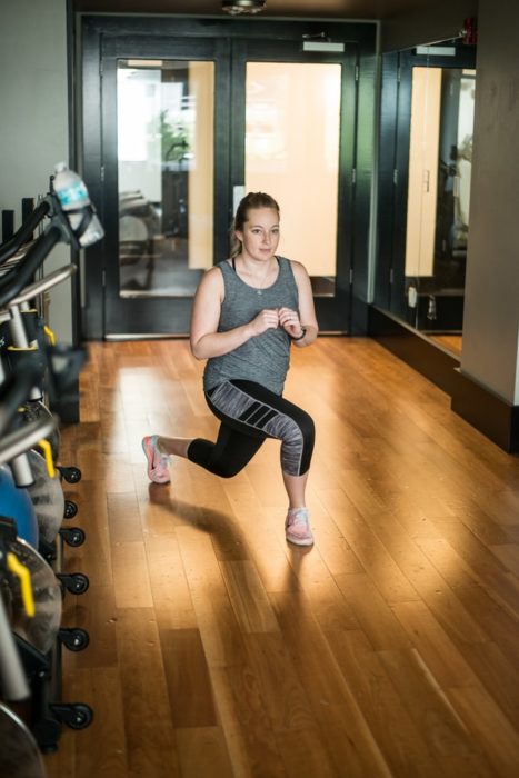 Chica realizando desplantes en gimnasio, con ropa de deporte