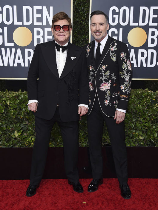 Elton John y David Furnish posando abrazados durante los Globos de Oro 2020