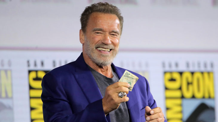 Arnold Schwarzenegger sosteniendo un dólar en una comic con