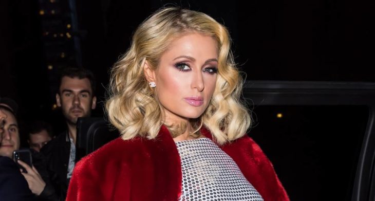 Paris Hilton con abrigo rojo posando para una selfie