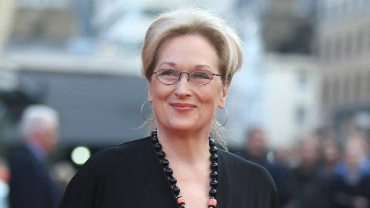 Meryl Streep sonriendo y llevando lentes en una alfombra roja