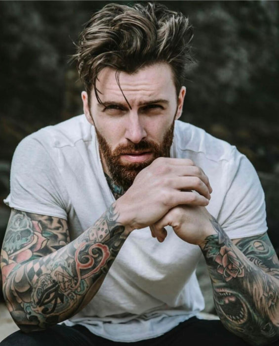 Mujeres prefieren a hombres con barba, tatuados y con panza; guapo chico con los brazos tatuados, barba y cabello corto