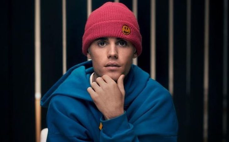 Justi Bieber sentado en una silla modelando su línea de ropa deportiva