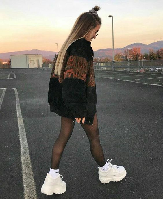 Chica con tenis de plataforma altos y chaqueta negra