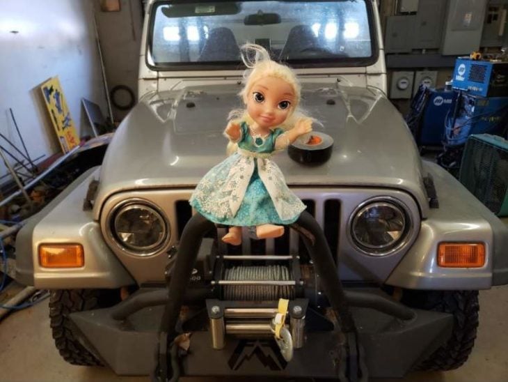 Muñeca Elsa sujetada al frente de un camión Jeep 