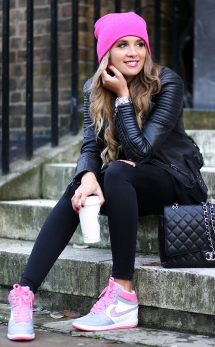 Chica llevando outfit en tono negro con tenis y gorro en rosa fucsia 