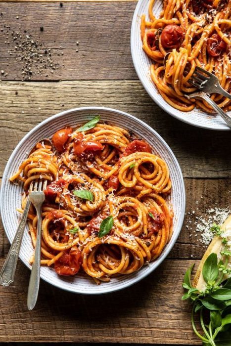 Pasta con tomate y especias sobre mesa de madera