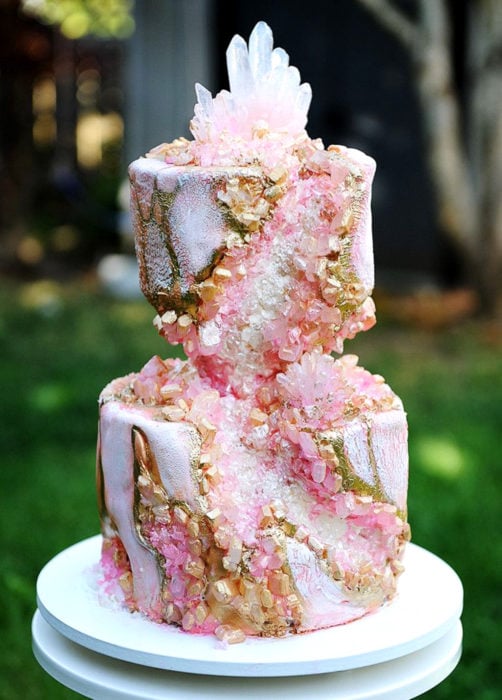 Pastel de boda rosa con blanco de dos pisos con piedras preciosas, cuarzos
