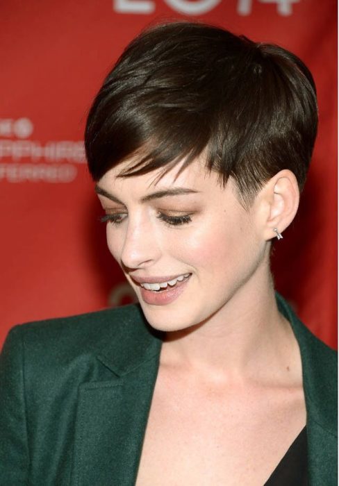 Anne Hataway con corte pixie usando una americana verde oscuro