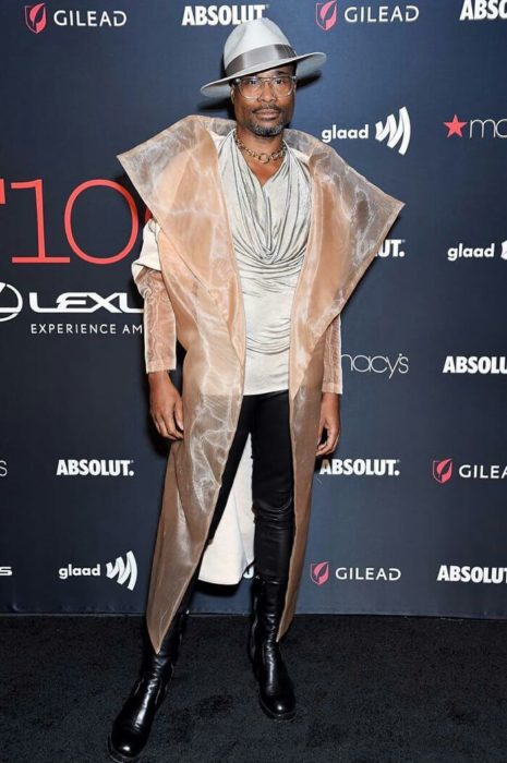 Billy Porter usando un atuendo en color arena con sombrero y jeans negros 