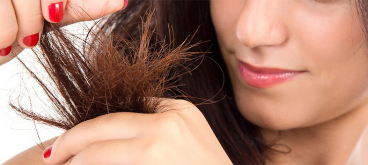 Chica observando las puntas abiertas de su cabello