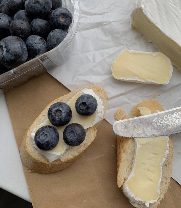 Snack de queso con arándanos frescos sobre una rebanada de pan