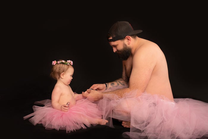 Padre e hija usando tutu sentados en el piso pintándose las uñas