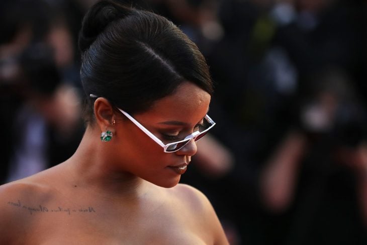 Rihanna mostrando el tatuaje que tiene en el hombro 