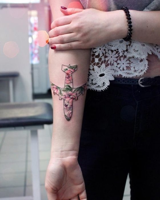 Tatuaje en el antebrazo con diseño de avión con flores de colores