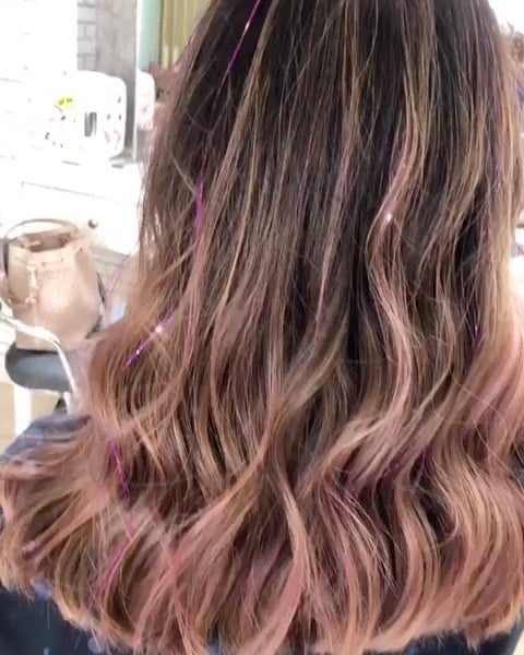 Chica con extensiones de glitter en color rosa y plateado 
