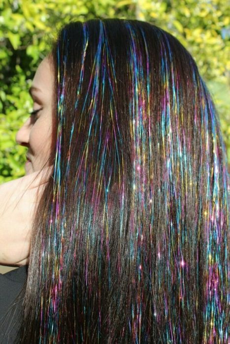 Chica usando extensiones de glitter en el cabello 