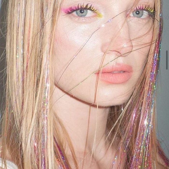 Chica usando extensiones de glitter en el cabello 