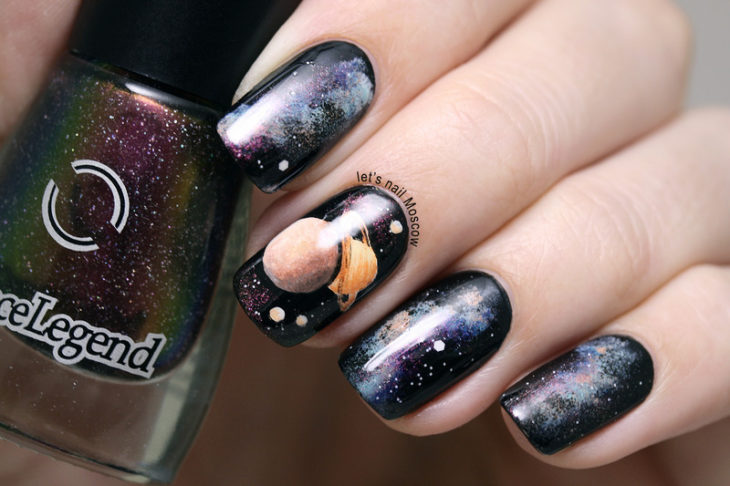 Uñas en negro con diseños de planetas en colores