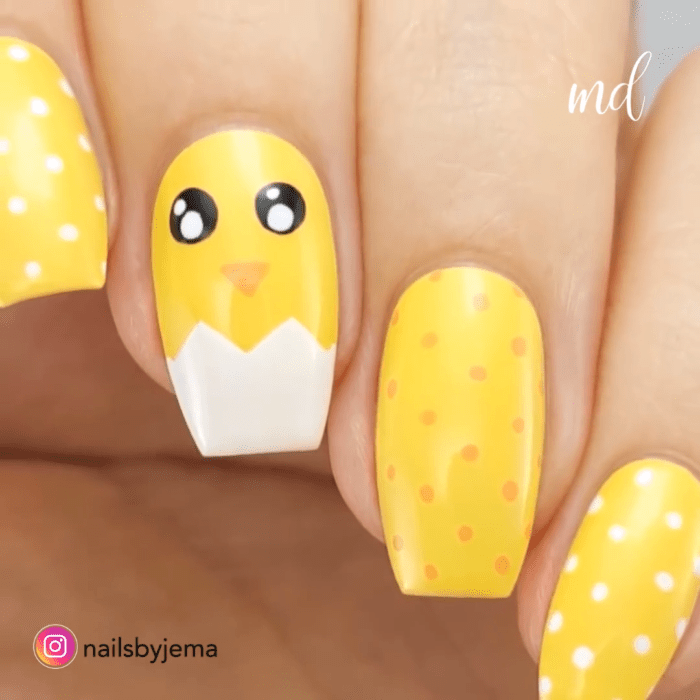 Chica con las uñas pintadas de color amarillo y decoradas con un pollito