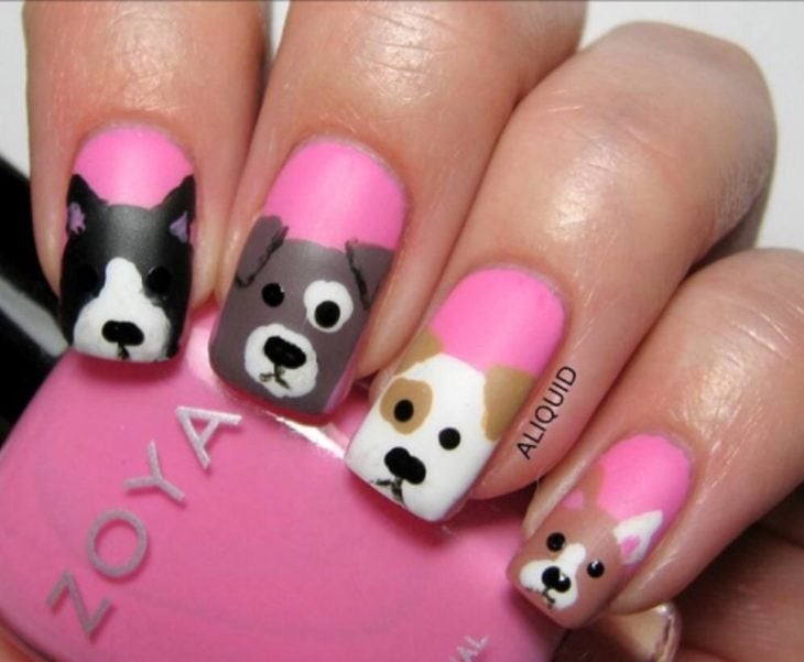 Chica con un las uñas de las manos pintadas de color rosa y con perritos 