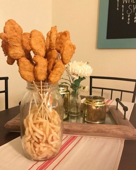 Ramo de nuggets puesto dentro de un embace que tiene papas fritas 