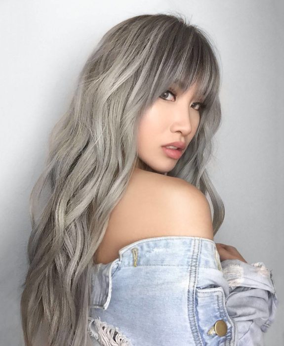 Chica con el cabello teñido en color rubio cenizo platinado con flequillo 