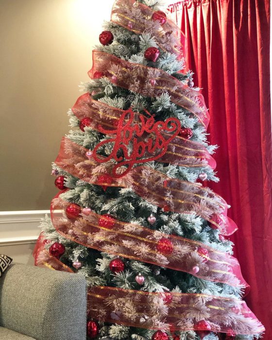 árbol de navidad decorado con guirnaldas rojas para festejar San Valentín 