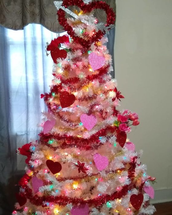 árbol de navidad decorado con guirnaldas rojas para festejar San Valentín 