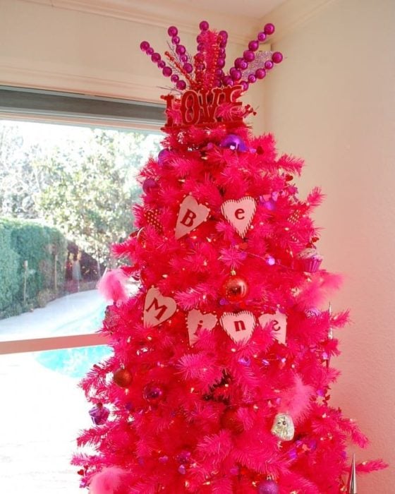 árbol de navidad decorado con guirnaldas rojas para festejar San Valentín 