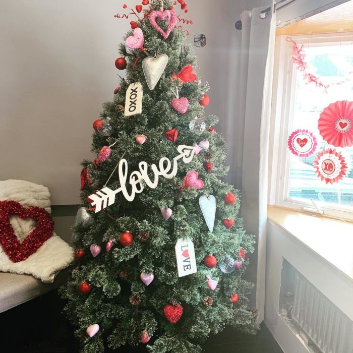 árbol de navidad decorado con guirnaldas rojas para festejar San Valentín 