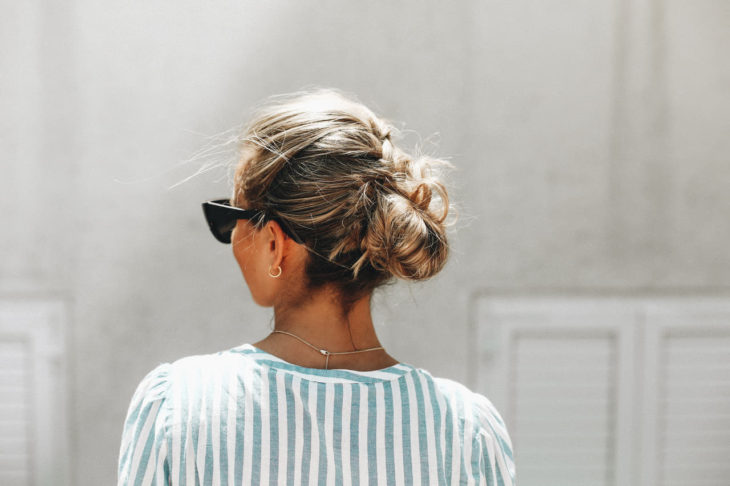 Chica con un moño bajo usando gafas de sol