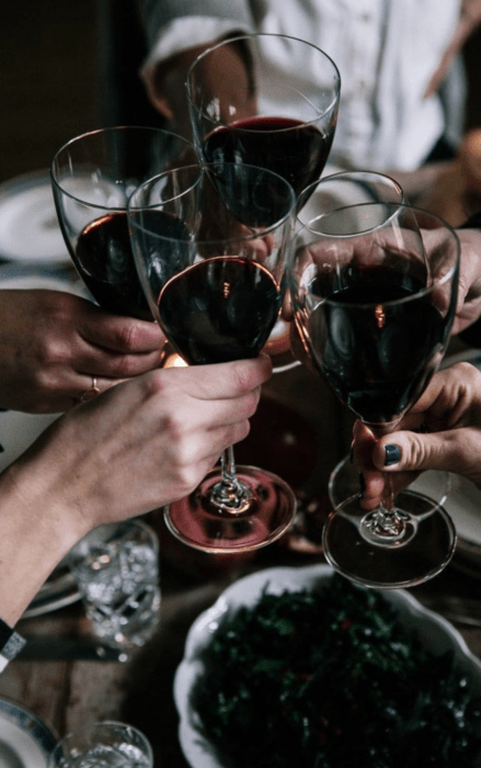 Grupo de chicas brindando con copas de vino tinto