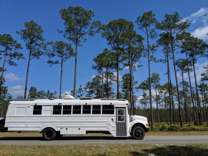 Autobús escolar en color blano viajando por la carretera