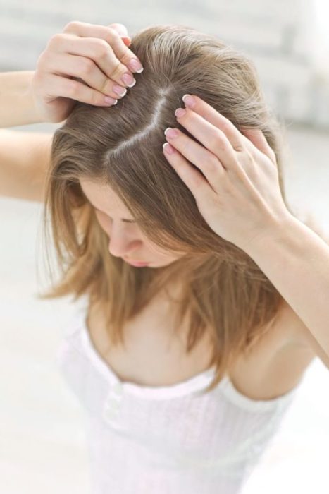 Mujer de cabello castaño mostrando la raíz de su cabello