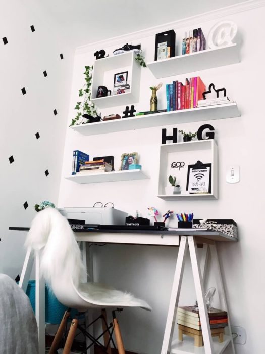 Habitación blanca con repisas, escritorio y silla blanca con detalles negros 