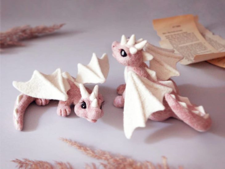 Pareja de dragones rosados con alas blancas hechos con fieltro y a mano