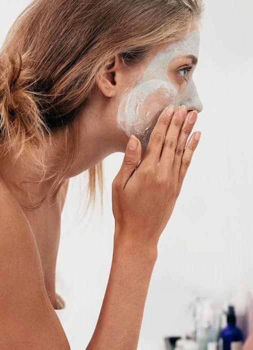 Mujer exfoliando su rostro