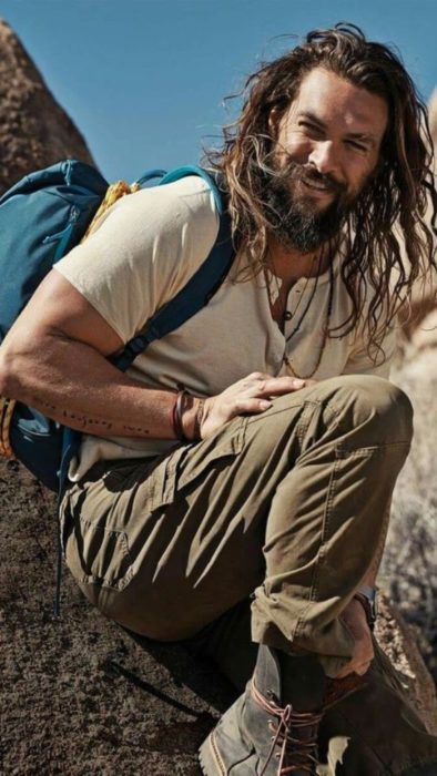 Fondo de pantalla para celular con Jason Momoa sobre una roca