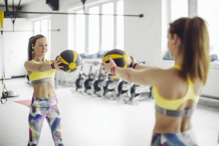 Mujer realizando giros de cintura con pelota 